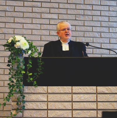 Entinen kirkkoherra Oiva Alanen saarnaamassa papin juhla-asussa.