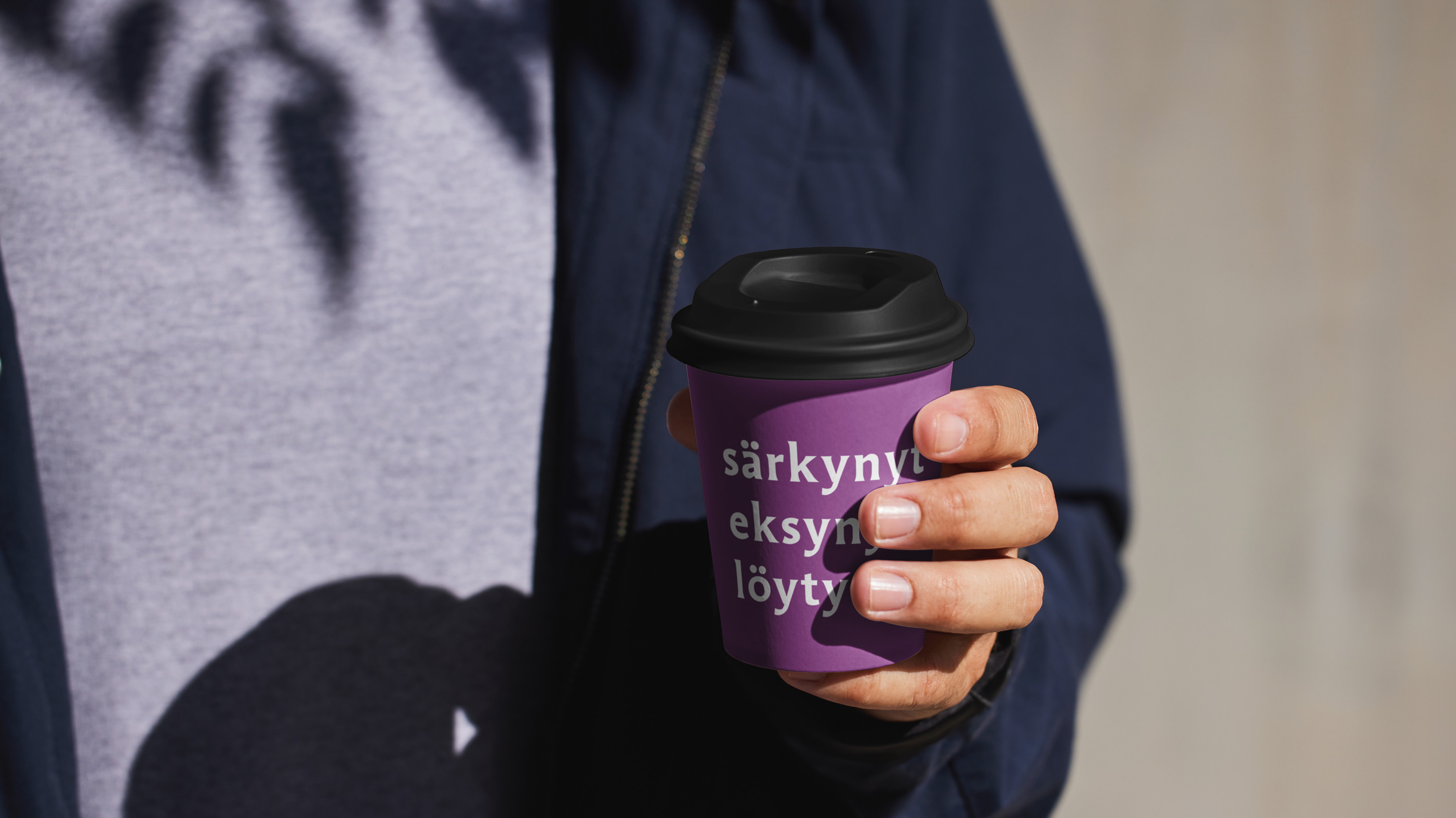 Kuva kahvikupista henkilön kädessä, kupissa osin näkyvissä sanat särkynyt, eksynyt, löytynyt.